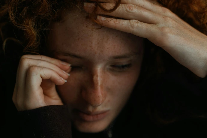 a close up of a person holding their head