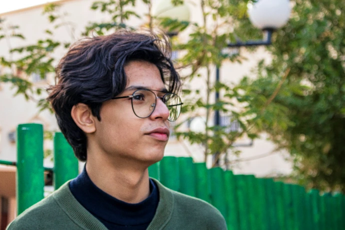 man in green crew neck shirt wearing black framed eyeglasses